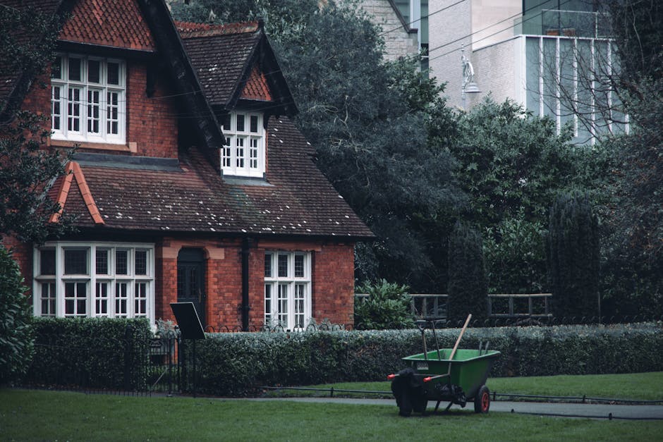 A well-maintained public garden featuring neatly trimmed green lawns and flower beds with colorful blooms, including pink, purple, and white flowers. The garden showcases a variety of plants, such as 